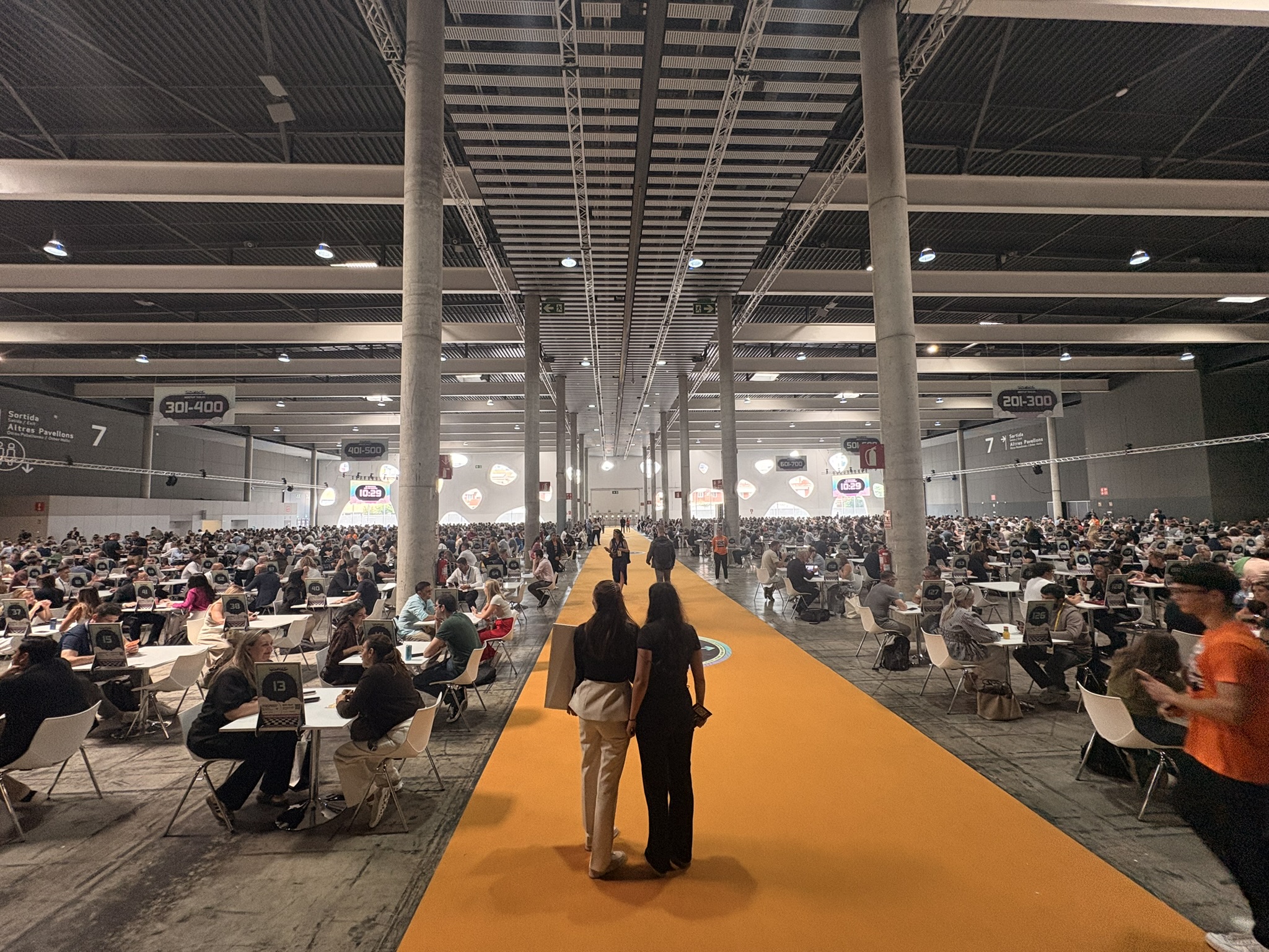 The main meeting hall at Shoptalk Europe 2026, thousands of attendees at tables along the orange walkway