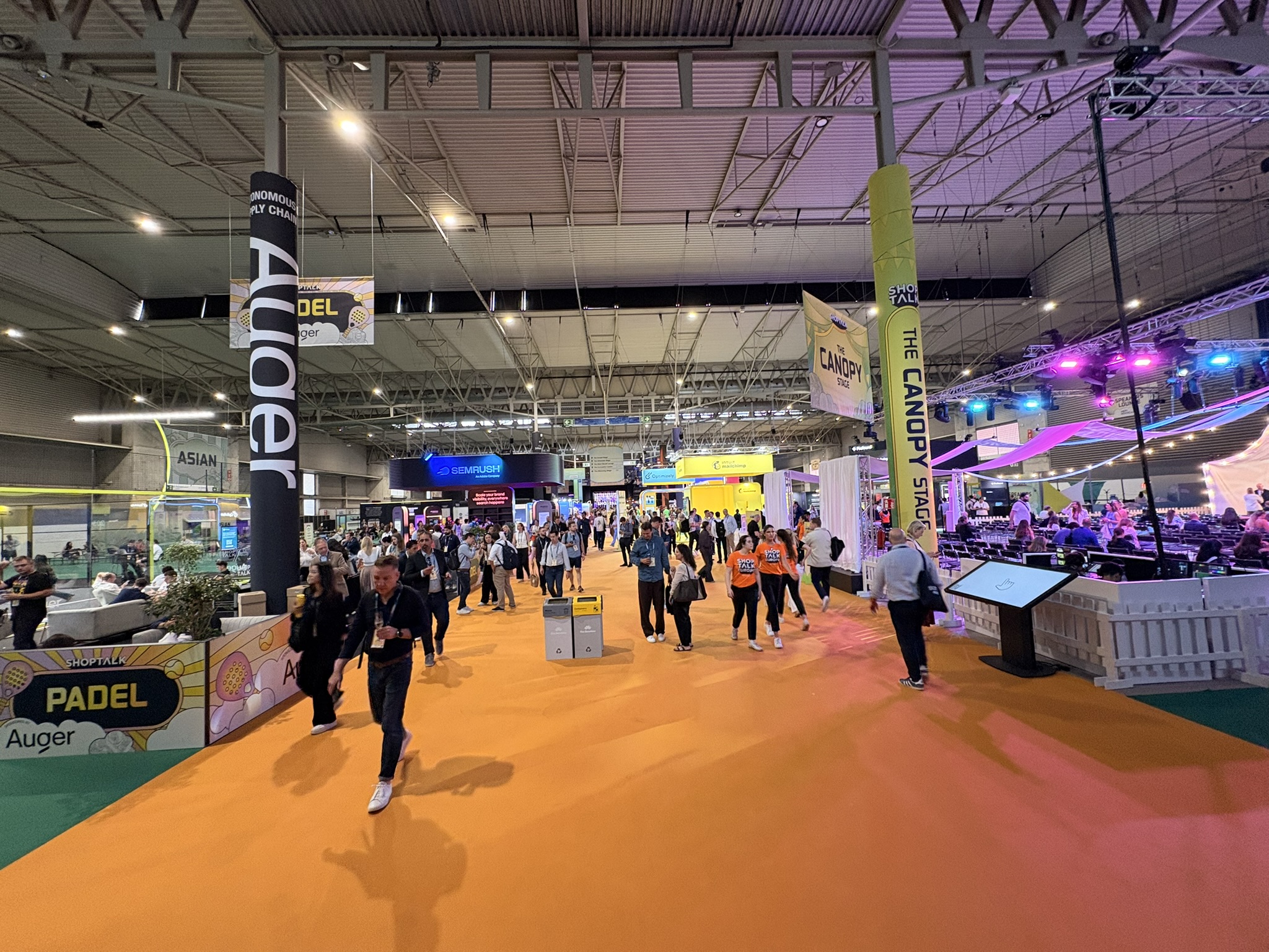 The Shoptalk Europe 2026 expo floor, crowds walking the orange carpet past stands